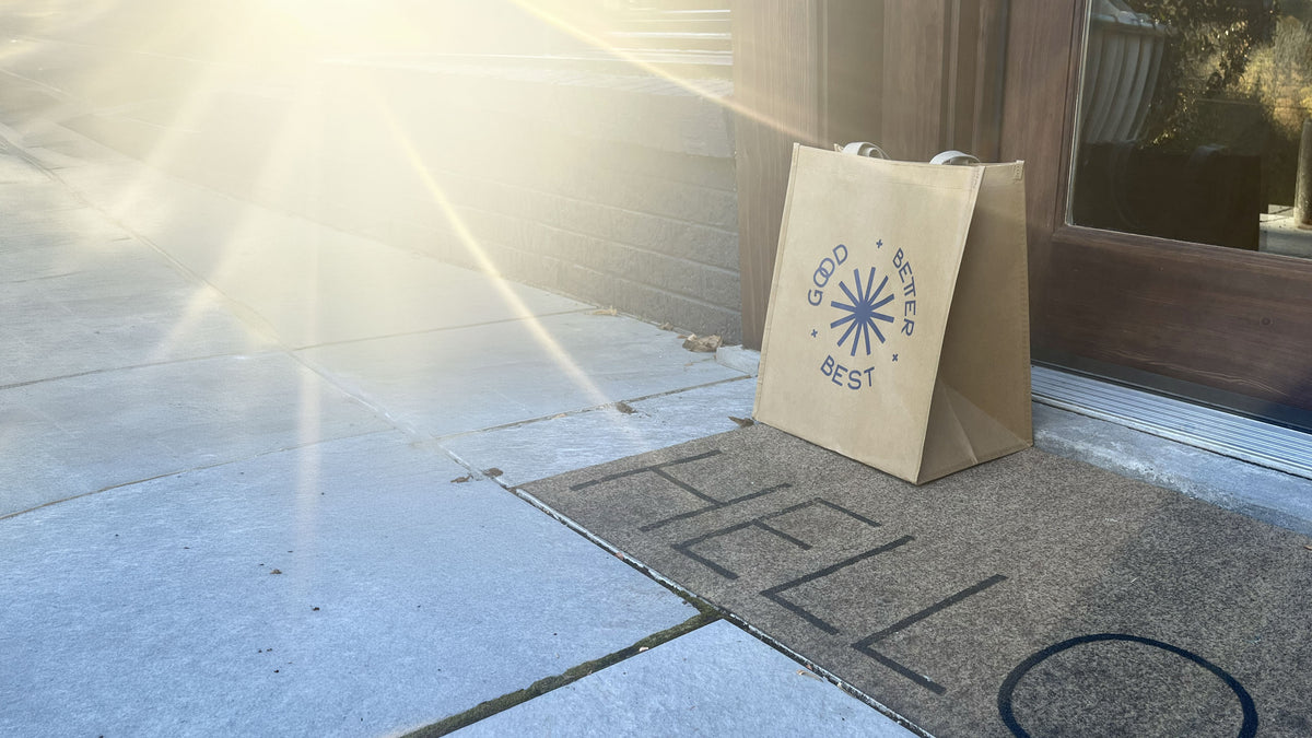 Good Better Best Reuseable delivery bag on a paved doorstep with the sunshine spilling in